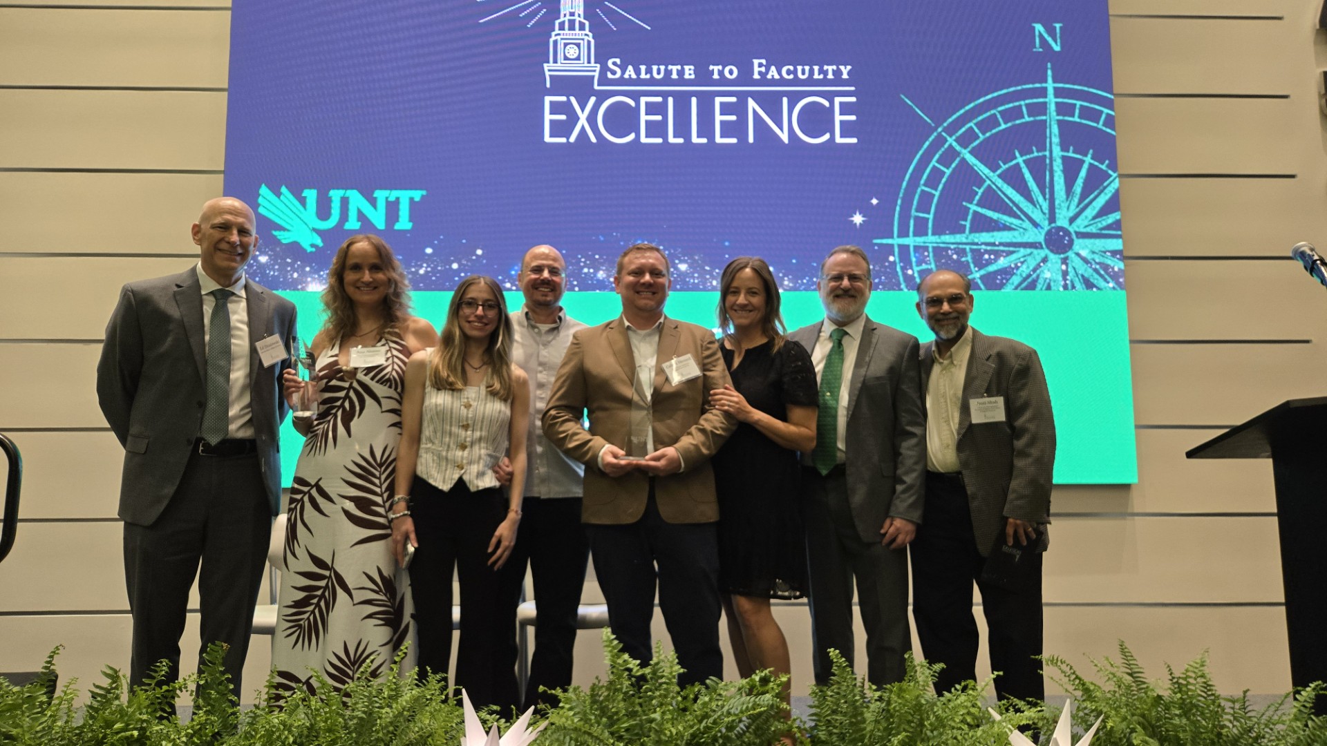 8 individuals posing for a photo at the faculty excellence award ceremony