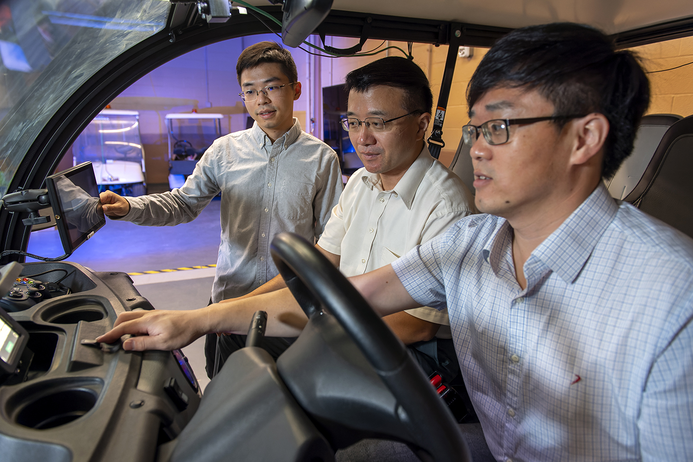 Photo of engineering students and faculty working on an autonomous car at UNT's Discovery Park